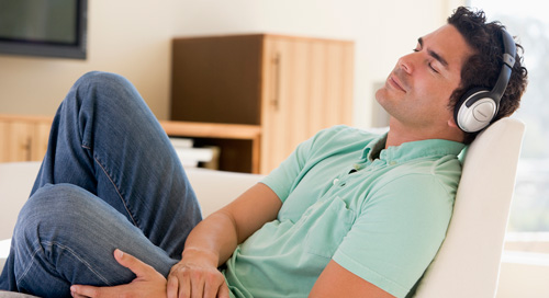 Man listening to headphones on couch